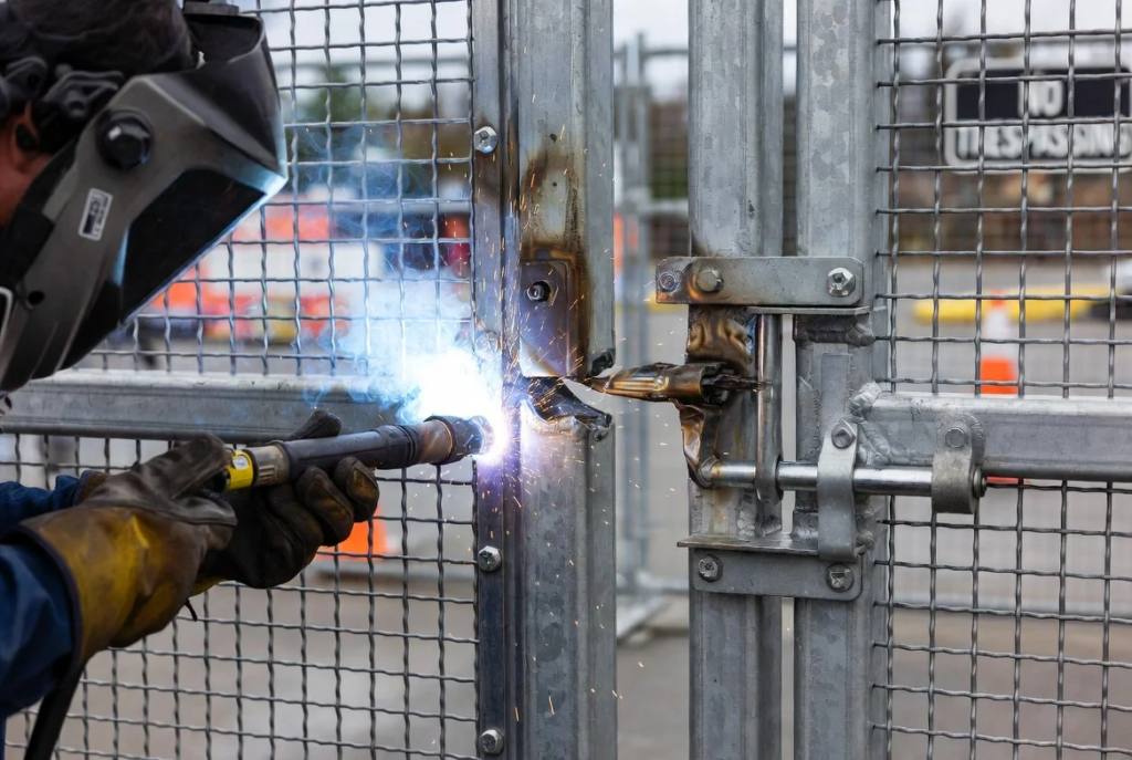 6. TIG MIG weld on heavy-duty hinge and latch assembly, temporary security barriers in place
